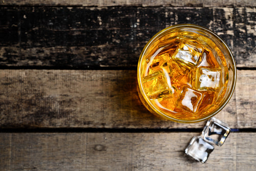 Glass of bourbon on table